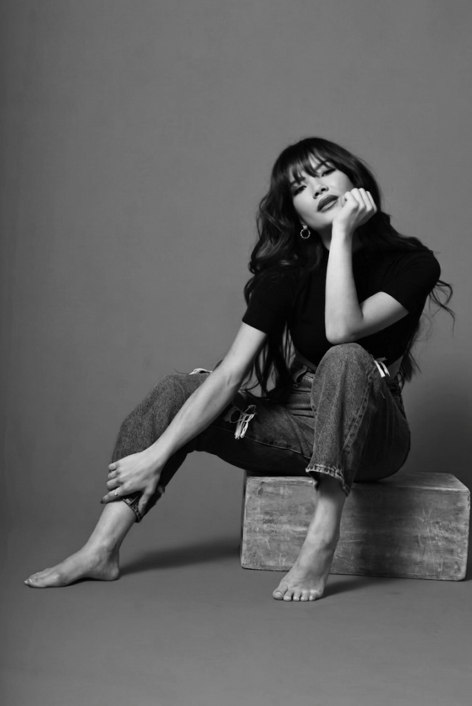 Adrianna Siena — Hero Portrait Black-and-white editorial portrait of Adrianna Siena seated in a studio.